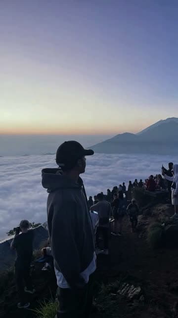 A hiker above the clouds at sunrise, a still from a photo animated into video
